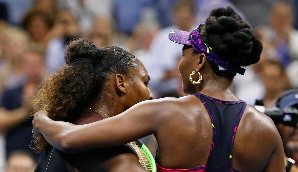 Petenis Serena Williams (kiri) memeluk kakak perempuannya, Venus Williams usai bertanding di putaran ketiga turnamen tenis AS Terbuka di New York, Jumat (31/8). Serena mengalahkan Venus dengan skor 6-1, 6-2. (AP Photo/Adam Hunger)