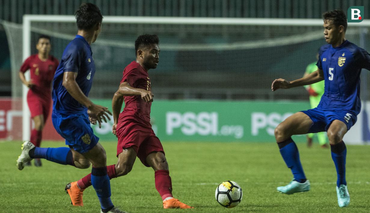 Gelandang Timnas Indonesia, Saddil Ramdani, berusaha melewati bek Thailand, Anuson Jaiphet, pada laga PSSI 88th U-19 di Stadion Pakansari, Jawa Barat, Minggu (23/9/2018). Kedua negara bermain imbang 2-2. (Bola.com/Vitalis Yogi Trisna)