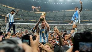 Pemain Argentina Lionel Messi mengangkat trofi juara di depan para penggemar usai mengalahkan Prancis pada pertandingan sepak bola final Piala Dunia 2022 di Stadion Lusail, Lusail, Qatar, 18 Desember 2022. Argentina menang 4-2 dalam adu penalti setelah pertandingan berakhir imbang 3 -3. (AP Photo/Martin Meissner)