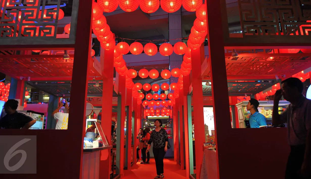 Pengunjung melintas di antara ratusan lampion yang terpasang di Mall Taman Anggrek, Jakarta, Jumat (20/1). Keberadaan lampion tersebut menjadi daya tarik pengunjung untuk sekedar melihat-lihat. (Liputan6.com/Angga Yuniar)
