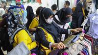 Calon pembeli memilih baju di Pasar Tanah Abang, Jakarta, Sabtu (23/4/2022). Menjelang Lebaran, Pasar Tanah Abang dipadati pengunjung yang memburu busana atau pakaian muslim untuk menyambut Hari Raya Idul Fitri 1443 Hijriah. (Liputan6.com/Herman Zakharia)
