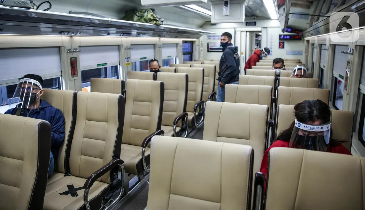 Penumpang menggunakan pelindung wajah berada di kereta jarak jauh di Stasiun Pasar Senen, Jakarta Pusat, Jumat (10/7/2020). PT. KAI membagikan face shield kepada penumpang bertujuan memudahkan masyarakat tetap dapat menjaga physical distancing di tengah pandemi COVID-19. (Liputan6.com/Faizal Fanani)