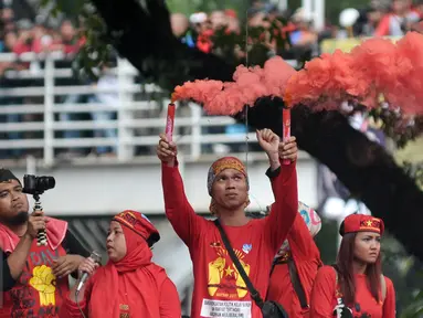 Buruh menyalakan flare saat aksi Hari Buruh di Jalan Medan Merdeka, Jakarta, Senin (5/1). Minta diperbolehkan mendekat ke Istana Negara, buruh menyalakan kembang api dan flare. (Liputan6.com/Yoppy Renato)