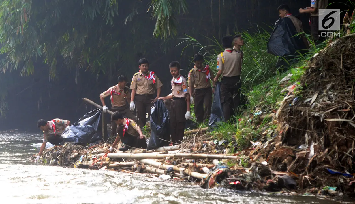 Anggota Pramuka memunguti sampah di aliran sungai saat kegiatan Bebersih Ciliwung di Yayasan Bambu Indonesia, Cibinong, Bogor, Jawa Barat, Minggu (23/6/2019). Kegiatan gotong royong ini digelar oleh Kementerian Lingkungan Hidup dan Kehutanan (KLHK). (merdeka.com/Arie Basuki)