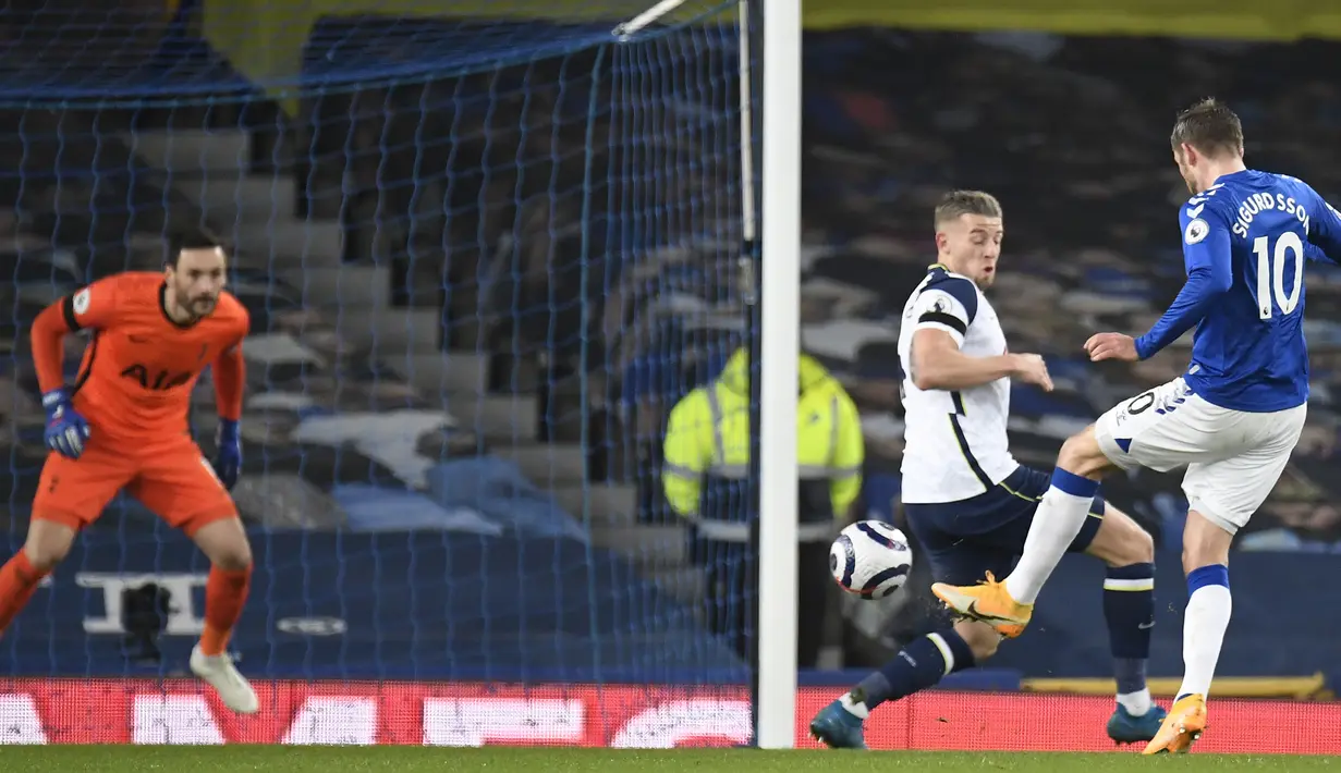 Gelandang Everton, Gylfi Sigurdsson (kanan) melepaskan tendangan yang berbuah gol kedua timnya ke gawang Tottenham Hotspur dalam laga lanjutan Liga Inggris 2020/2021 pekan ke-32 di Goodison park, Liverpool, Jumat (16/4/2021). Everton bermain imbang 2-2 dengan Tottenham. (AP/Peter Powell/Pool)