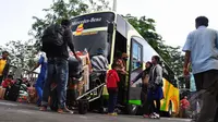 Para pemudik bersiap menaiki bus yang akan memberangkatkan mereka ke kampung halaman (Liputan6.com/Faizal Fanani)