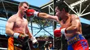 Petinju Filipina, Manny Pacquiao, mendaratkan pukulan ke Jeff Horn (Australia) pada perebutan sabuk juara kelas welter versi WBO di Stadion Suncorp, Brisbane, Minggu (2/7). Horn mengalahkan Pacquiao dalam pertarungan 12 ronde. (PATRICK HAMILTON/AFP) 