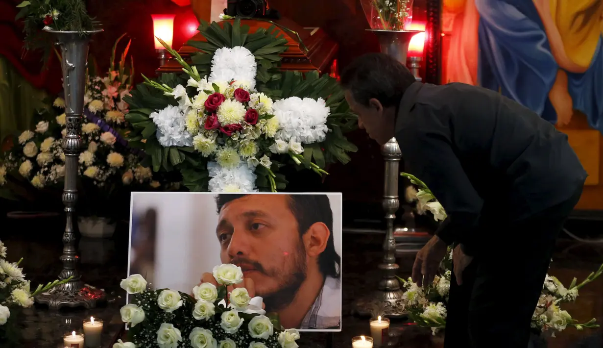 Seorang kerabat berdiri di samping peti Ruben Espinosa, Meksiko, Minggu (2/8/2015). Veracruz menjadi negara bagian yang berbahaya bagi para wartawan, 11 wartawan tewas di sana sejak tahun 2010. (REUTERS/Henry Romero)