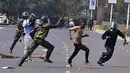 Polisi Kenya berusaha memukul seorang pengunjuk rasa saat bentrok di Nairobi, Kenya (16/5/2016). Mereka menuntut pembubaran otoritas pemilu karena adanya dugaan korupsi. (AFP PHOTO/SIMON Maina)