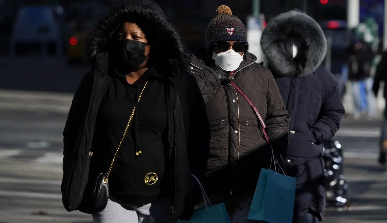 Pejalan kaki mengenakan mantel tebal melawan dingin di New York, Selasa (11/1/2022). Massa udara kutub utara menyapu timur laut AS, membawa suhu di bawah nol yang menusuk tulang dan menutup sekolah di seluruh wilayah untuk kedua kalinya dalam waktu kurang dari seminggu. (AP Photo/Seth Wenig)