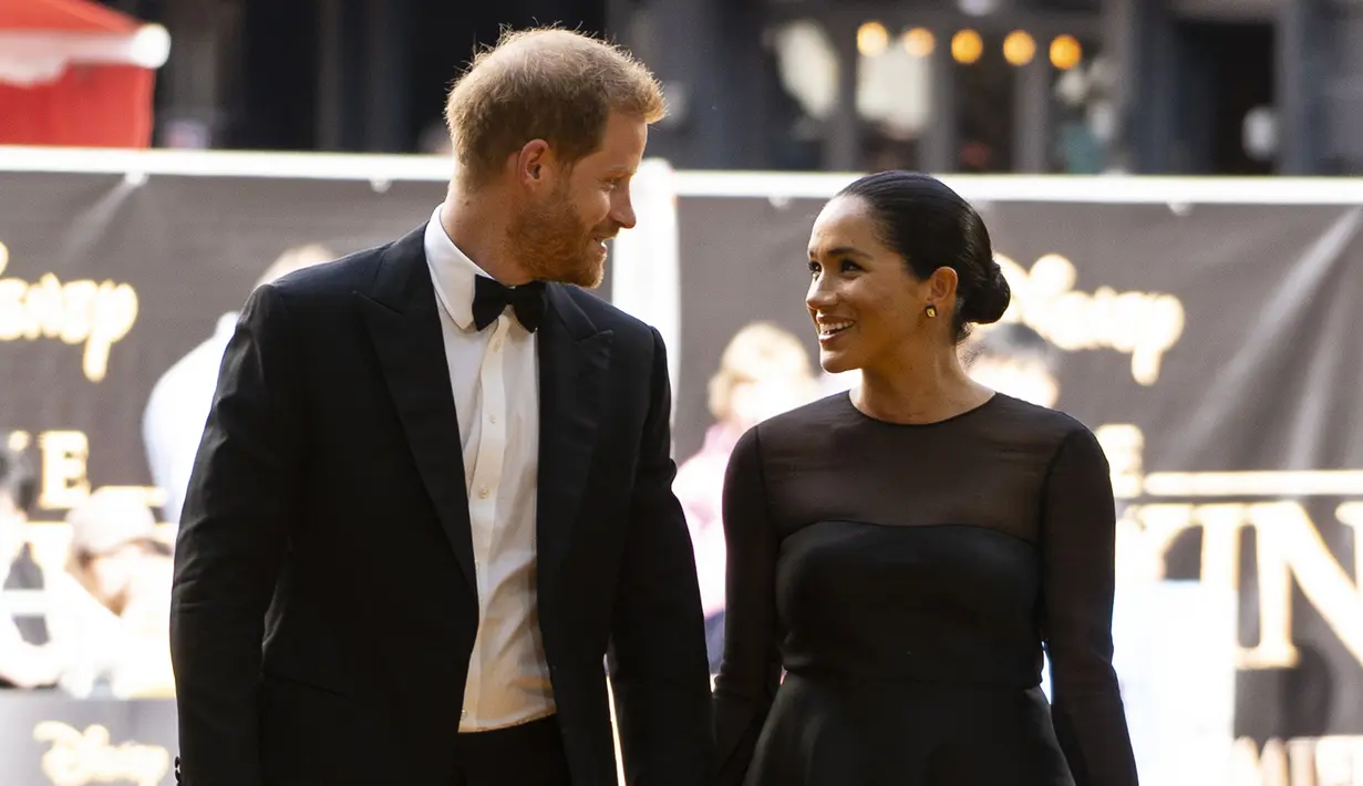 Pangeran Harry dan Meghan Markle bergandengan tangan saat tiba menghadiri pemutaran film The Lion King di London (14/7/2019). Kehadiran keduanya menjadi kejutan, mengingat ini kali pertama keduanya muncul di red carpet selebriti setelah menikah pada Mei 2018 lalu. (AFP Photo/Niklas Halle'n)