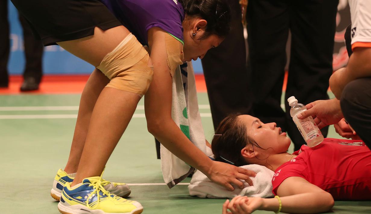 Linda Wenifanetri, membantu pebulutangkis Thailand, Ratchanok Intanon, yang mengalami cedera saat bertanding di babak 16 Besar Kejuaraan Dunia Bulutangkis 2015 di Istora Gelora Bung Karno, Jakarta. Kamis (13/8/2015). (Bola.com/Arief Bagus)