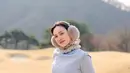 Ia kenakan outfit berlapis yang terdiri dari long sleeve dan sleeveless sweater abu-abu. Dipadu dengan ruffle collar dan celana putih [@shandyaulia]
