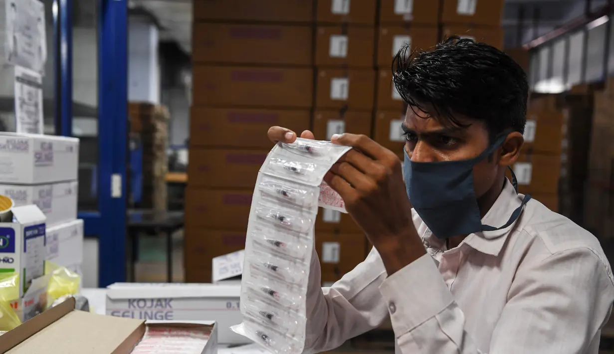 Pekerja memeriksa jarum suntik yang sudah jadi sebelum pengepakan, di pabrik Jarum Suntik Hindustan di Faridabad (2/9/2020). Produksi jarum suntik ditingkatkan mengantisipasi lonjakan permintaan saat perlombaan global untuk menemukan vaksin virus corona COVID-19 memanas. (AFP/Sajjad Hussain)