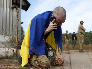 Seorang prajurit Ukraina menelepon setelah dibebaskan dari tawanan Rusia di sebuah lokasi yang dirahasiakan di dekat perbatasan Ukraina-Belarusia, pada 13 September 2024. (Anatolii STEPANOV/AFP)