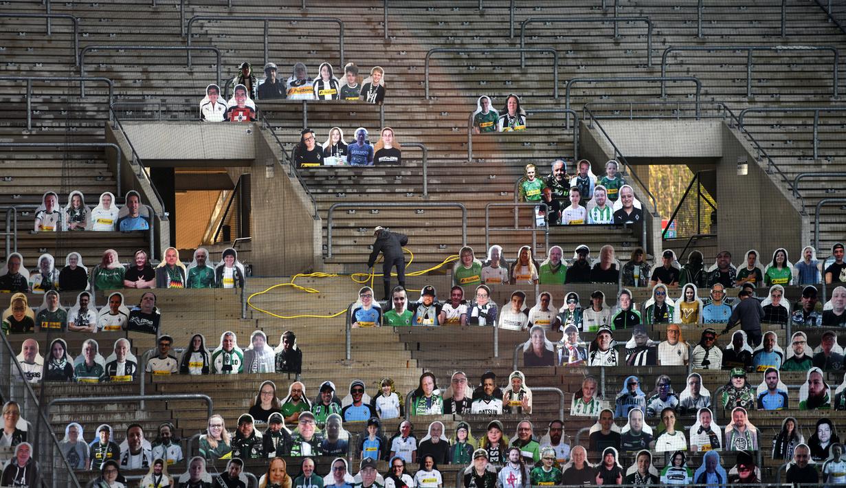 Cardboard pendukung Borussia Moenchegladbach mengisi kursi penonton di stadion Borussia Park, Moenchengladbach, Jerman, Rabu (20/5/2020). Ribuan Cardboard gambar suporter Borussia Moenchegladbach dipasang untuk mendukung timnya saat berlaga di kompetisi Bundesliga. (AFP/Ina Fassbender)
