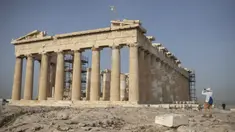 Seorang pria mengambil gambar Kuil Parthenon di Bukit Acropolis, Athena, Yunani, Senin (18/5/2020). Yunani kembali membuka kota kuno Acropolis serta situs-situs lainnya setelah dua bulan ditutup selama lockdown akibat pandemi virus corona COVID-19. (AP Photo/Petros Giannakouris)