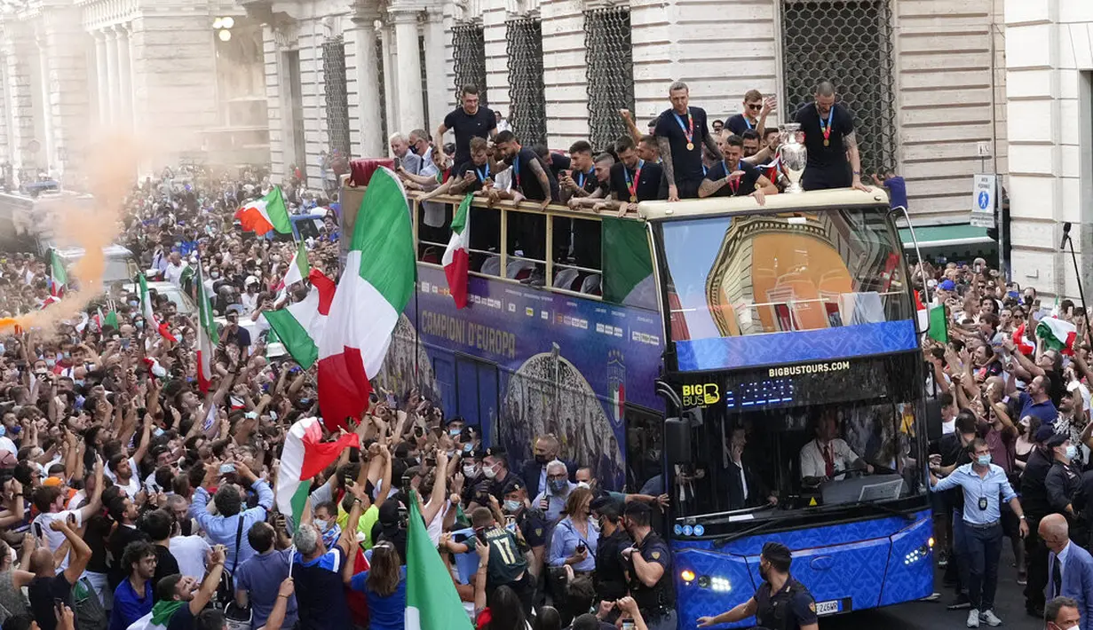 Para pemain Italia berada di atas bus saat perayaan juara Euro 2020 di Roma, Senin (12/7/2021). Italia mengalahkan Inggris 3-2 dalam adu penalti setelah bermain imbang 1-1 pada final Euro 2020 di stadion Wembley di London. (AP Photo/Gregorio Borgia)
