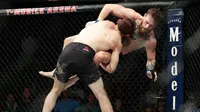 Khabib Nurmagomedov membanting Conor McGregor dalam pertarungan UFC 229 di Las Vegas, AS (6/10). Nurmagomedov mengalahkan McGregor dan berhasil keluar sebagai pemenangnya. (AP Photo/John Locher)