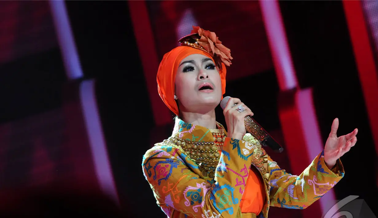 Iis Dahlia yang mengenakan gaun berwarna orange tampil memukau menghibur penonton di Malam Puncak Putri Muslimah Indonesia 2014, TMII, Jakarta, Rabu (28/5/2014) (Liputan 6.com/Andrian M Tunay)