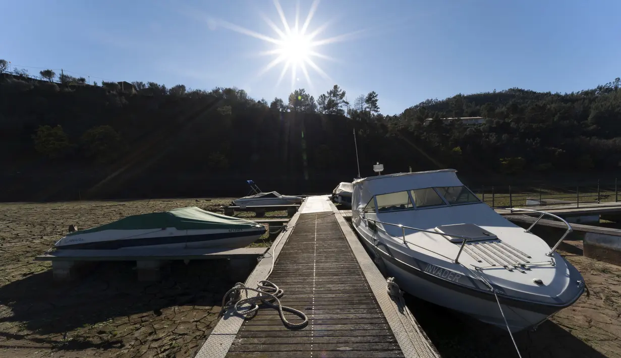 Kapal-kapal pesiar diikat ke dermaga di tanah kering dari air yang habis di Sungai Zezere karena kekeringan, dekat Figueiro dos Vinhos di Portugal, 17 Februari 2022. Pada akhir Januari, 45% negara itu mengalami kondisi kekeringan "parah" menurut badan cuaca nasional IPMA. (AP/Sergio Azenha)
