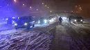 Sejumlah mobil terjebak salju tebal yang menyelimuti Jalan Lingkar M30 di Madrid, Spanyol, Jumat (8/1/2021). Otoritas Madrid mengimbau warga untuk menghindari perjalanan yang tidak penting akibat Badai Filomena. (OSCAR DEL POZO/AFP)