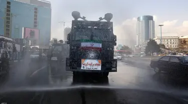 Kendaraan Water Canon kepolisian menyempotkan desinfektan untuk mensterilkan jalan-jalan di Teheran, Iran pada 1 Maret 2020. Sejauh ini, Iran mencatat ada 1.501 kasus virus Corona dengan 66 korban meninggal. (AP Photo/Vahid Salemi)