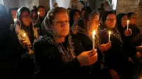 Para jemaah yang melakukan ibadah di gereja di Bartella untuk merayakan Natal (Reuters)