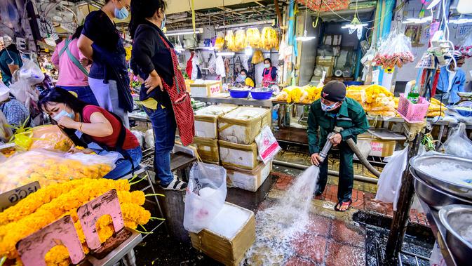 Pekerja Otoritas Metropolitan Bangkok menyapu lantai saat membersihkan dan mendisinfeksi Pasar Bunga Yodpiman di Bangkok (6/1/2021).  Thailand melaporkan 745 kasus virus corona baru hari ini, Senin (4/1/2020).  (AFP/Mladen Antonov)
