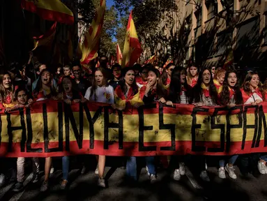 Demonstran memegang spanduk bertuliskan 'Catalonia adalah Spanyol' menentang deklarasi kemerdekaan Catalonia, di Barcelona, Spanyol, (29/10). Mereka menyerukan persatuan dan menolak deklarasi kemerdekaan Catalan. (AP Photo/Gonzalo Arroyo)