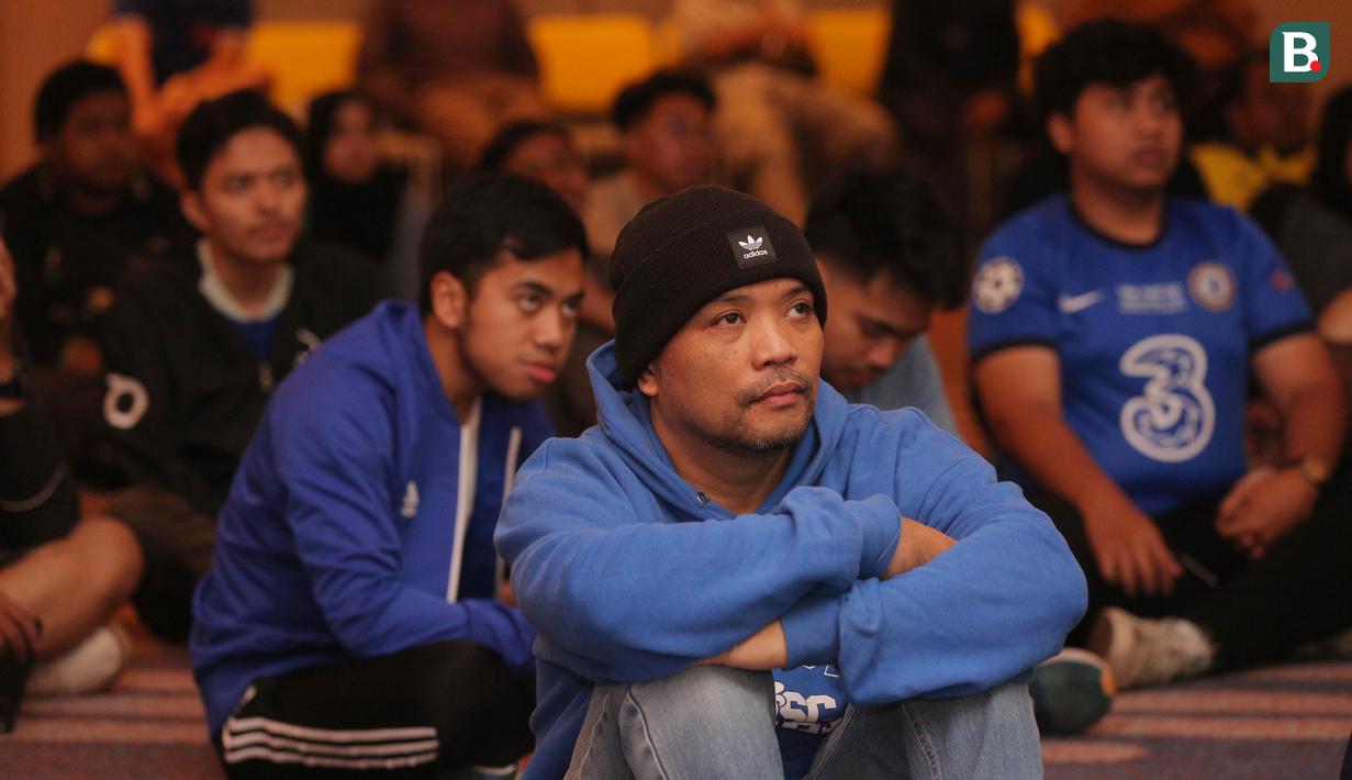 Seorang anggota komunitas suporter Chelsea CISC Regional Jakarta tampak serius menyaksikan pertandingan Premier League 2023/2024 antara Chelsea melawan Fulham dalam acara Roaring Night di Hotel Ibis Styles, Tanah Abang, Jakarta Pusat, Sabtu (13/1/2024) malam. (Bola.com/M Iqbal Ichsan)