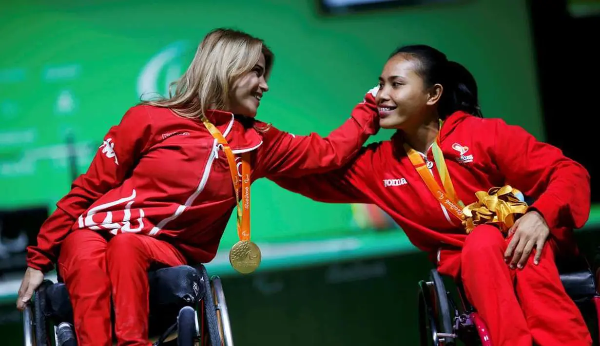 Atlet angkat berat Indonesia, Ni Nengah Widiasih (kanan), bersama peraih emas, Muratli Nazmiye (Turki), kelas -42 kg putri Paralimpiade Rio 2016 di Pavilion 2 Rio Centro, Brasil, Jumat (9/9/2016) dini hari WIB. (Reuters/Ueslei Marcelino)