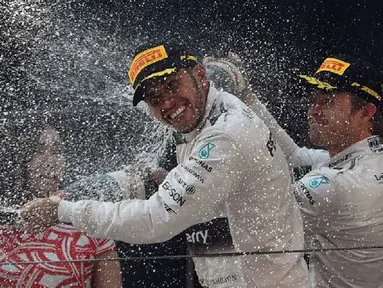 Nico Rosberg membalas menyemprotkan sampanye ke muka Lewis Hamilton
