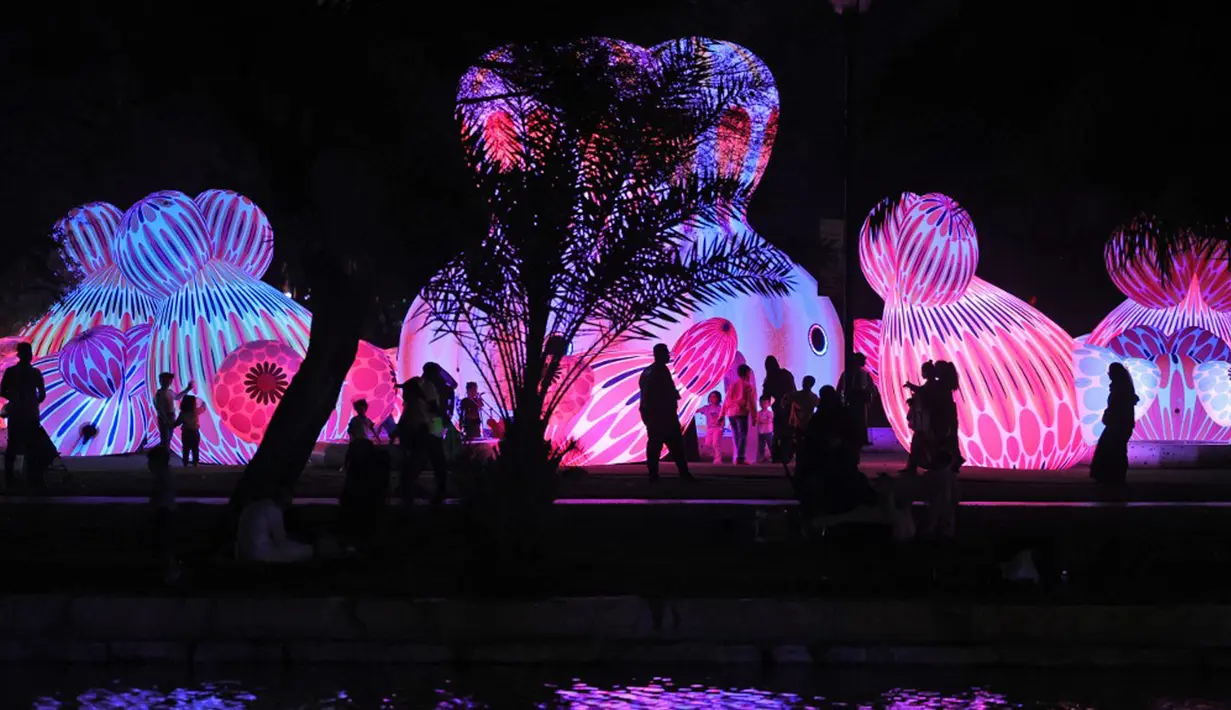 Warga menghadiri festival cahaya Noor Riyadh yang diadakan di Taman Al-Salam, Riyadh, Arab Saudi, 3 November 2022. Lebih dari 190 karya seni dipamerkan di ruang publik Riyadh selama festival cahaya Noor Riyadh, termasuk instalasi monumental dan interaktif serta patung-patung. (Fayez Nureldine/AFP)