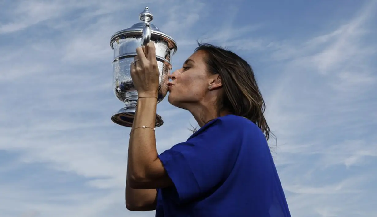 Petenis putri Italia, Flavia Penneta, berpose dengan trofi AS Terbuka di puncak the Rock, AS. Minggu (13/9/2015). (AFP Photo/Kena Betancur)