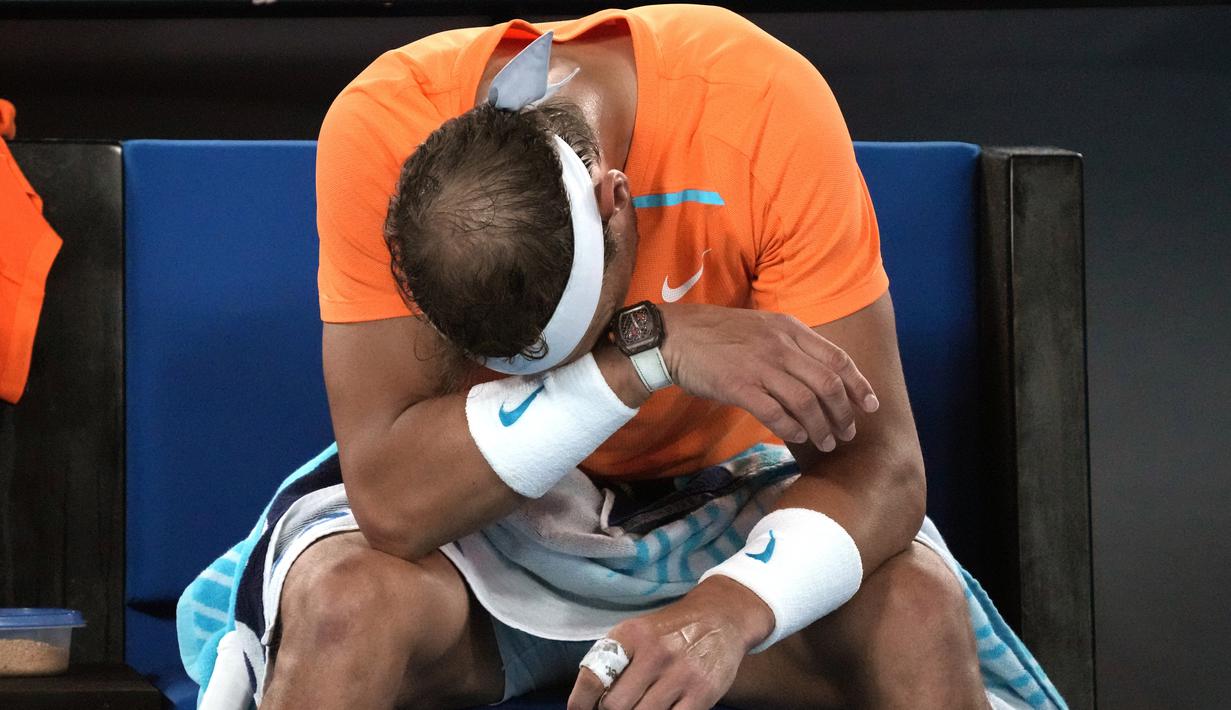 Petenis Spanyol, Rafael Nadal, tertunduk lesu usai ditaklukkan petenis Amerika Serikat, Mackenzie McDonald, pada Australian Open 2023 di Melbourne Park, Rabu (18/1/2023). Nadal kalah 6-4, 6-4, 7-5 dari Mackenzie. (AP Photo/Dita Alangkara)