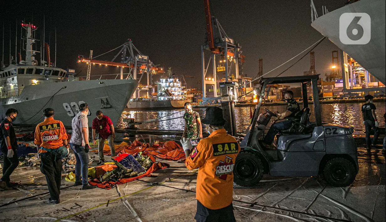 Petugas memindahkan serpihan Sriwijaya Air SJ 182 di Terminal JICT 2, Tanjung Priok, Jakarta, Kamis (21/1/2020).  Serpihan Sriwijaya Air SJ 182 dipindahkan dari Terminal JICT 2 ke kantor KNKT untuk dilakukan pemeriksaan dan identifikasi. (Liputan6.com/Faizal Fanani)