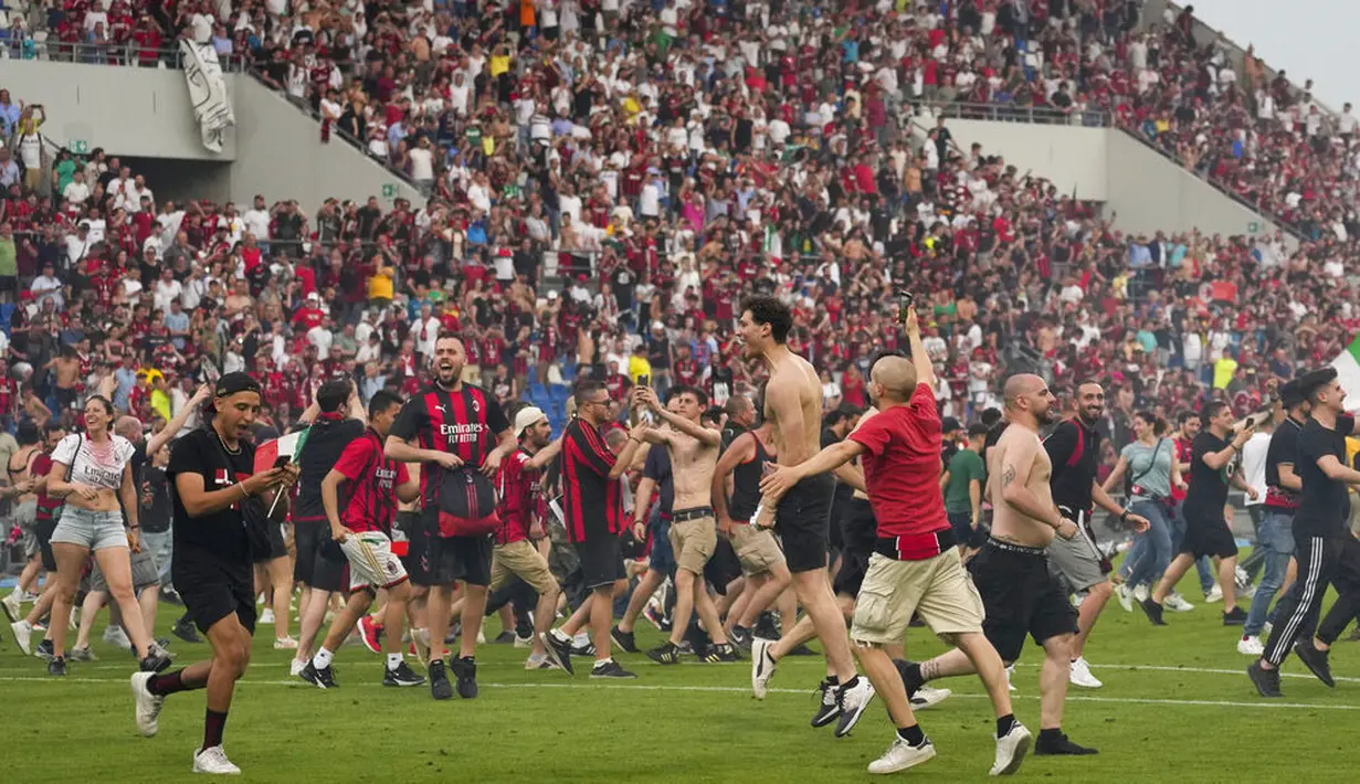 Para suporter tumpah ruah ke lapangan usai AC Milan dipastikan menjadi juara Serie A musim 2021/2022. (AP/Antonio Calanni)