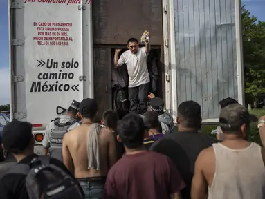 Migran mengambil barang-barang mereka setelah ditahan oleh otoritas imigrasi di Veracruz, Meksiko, Minggu, 23 Juli 2023. (AP Photo/Felix Marquez)