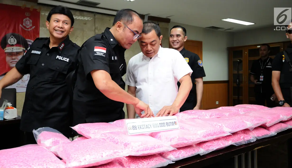 Kabareskrim Polri Komjen Pol Ari Dono Sukmanto (kiri) bersama Direktur Tindak Pidana Narkotika Bareskrim Polri Brigjen Eko Daniyanto memeriksa barang bukti 600 ribu butir ekstasi saat rilis di Jakarta, Kamis (23/11). (Liputan6.com/Helmi Fithriansyah)