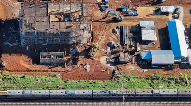 Rangkaian keret rel listrik (KRL) melintas di dekat proyek pembangunan Stasiun Jatake, Pagedangan, Kabupaten Tangerang, Banten, Selasa (9/7/2024). (merdeka.com/Arie Basuki)