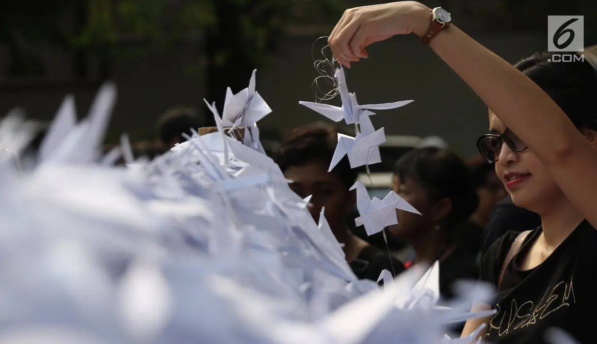Warga memasang burung origami di halaman Balai Kota, Jakarta, Sabtu (27/5). Seribu Origami Burung Perdamaian imi merupakan aksi atau gerakan spontanitas atas dasar kecintaan kepada Negara Kesatuan Republik Indonesia (NKRI). (Liputan6.com/Angga Yuniar)