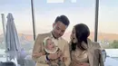 Jessica Mila terlihat glamor dengan gaun emas, sedangkan sang buah hati menggemaskan dengan baby attire dari Burberry lengkap dengan bandana yang menggemaskan. [Foto: instagram/ Jessica Mila]