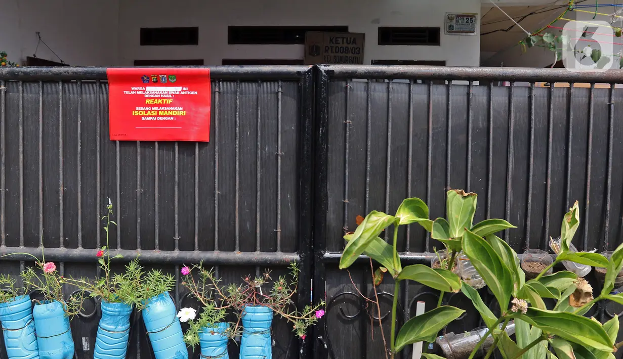 Pemberitahuan sedang melaksanakan isolasi mandiri terpasang pada pagar rumah warga di kawasan Intan Berduri, Sumur Batu, Jakarta, Rabu (9/06/2021). Kelurahan Sumur Batu memberlakukan mikro lockdown di RT 1, RT 2 dan RT di RW 03 setelah 34 warga positif COVID-19. (Liputan6.com/Herman Zakharia)