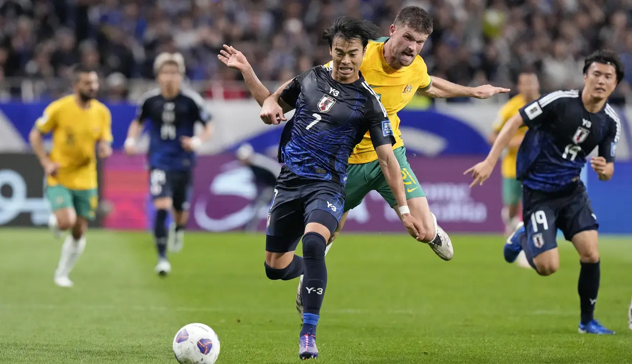 Pemain Jepang, Kaoru Mitoma (kiri) berebut bola dengan pemain Australia, Cameron Burgess saat laga lanjutan Grup C Kualifikasi Piala Dunia 2026 di Saitama Stadium, Jepang, Selasa (15/10/2024). (AP Photo/Eugene Hoshiko)