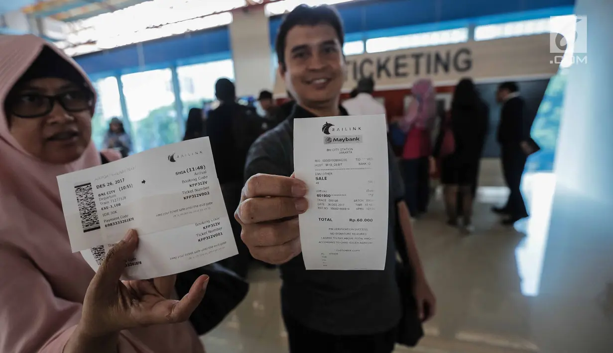 Calon penumpang menunjukkan tiket kereta Bandara Soekarno-Hatta di stasiun Sudirman Baru, Jakarta, Selasa (26/12). Kereta bandara terdiri dari enam kereta per rangkaian yang bisa menampung 272 penumpang dan 42 perjalanan. (Liputan6.com/Faizal Fanani)