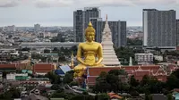 Patung Buddha raksasa setinggi 69 meter berdiri di kuil Wat Paknam Phasi Charoen di pinggiran Bangkok, Thailand pada Selasa (12/10/2021). Patung raksasa yang mulai dibangun tahun 2017 dan ukurannya setinggi gedung 20 lantai ini menghiasi langit kota metropolitan Bangkok. (Jack TAYLOR / AFP)