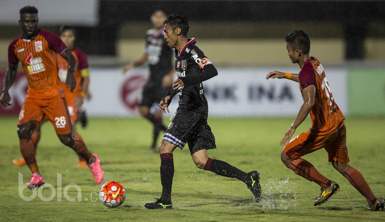 Kapten Bali United FC, Fadil Sausu menggiring bola melewati hadangan para pemain Pusamania Borneo FC pada laga Piala Presiden 2017 di Stadion I Wayan Dipta, Bali, Senin (13/2/2017). (Bola.com/Vitalis Yogi Trisna)