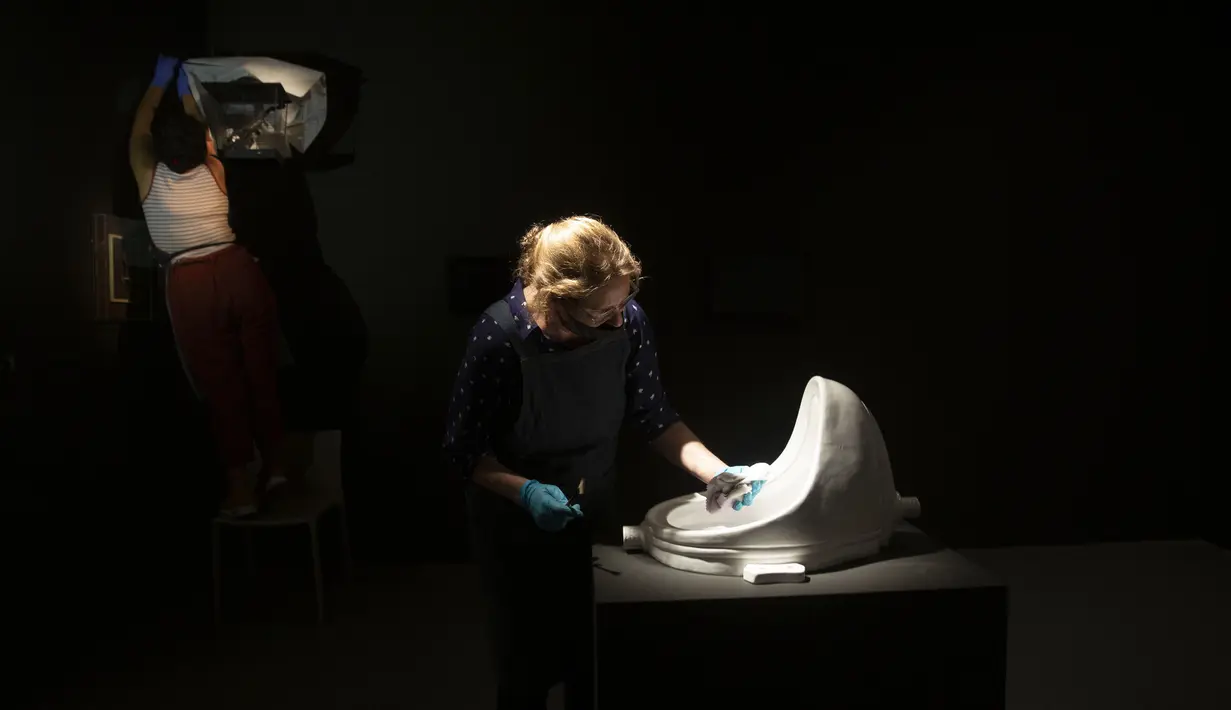 Pegawai Museum Israel membersihkan barang-barang yang dipamerkan selama persiapan terakhir untuk kembali dibuka, Yerusalem, Selasa (11/8/2020). Setelah lima bulan tutup karena pandemi COVID-19, Museum Israel akan kembali dibuka untuk umum pada minggu ini. (AP Photo/Maya Alleruzzo)