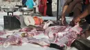 Panitia memotong-motong daging hewan kurban di kawasan Kampung Akuarium, Jakarta, Senin (12/9). Ratusan warga korban gusuran Kampung Akuarium Pasar Ikan merayakan Idul Adha 1437 H di antara reruntuhan rumah mereka. (Liputan6.com/Yoppy Renato)